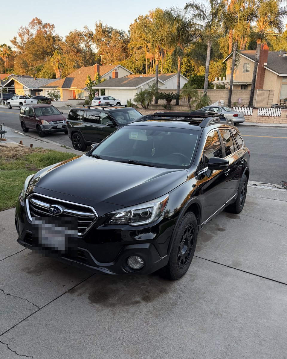 Black Subaru Outback after detailing, golden hour gloss