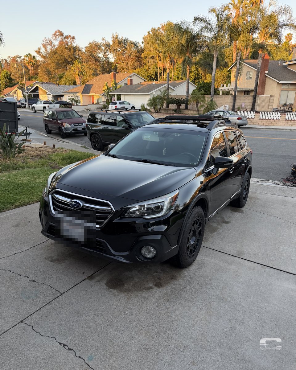 Black Subaru Outback at golden hour after detailing
